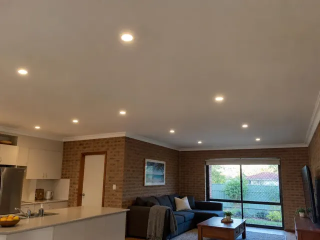 Living room with recessed downlights in a brick and plaster home interior in Gwandalan